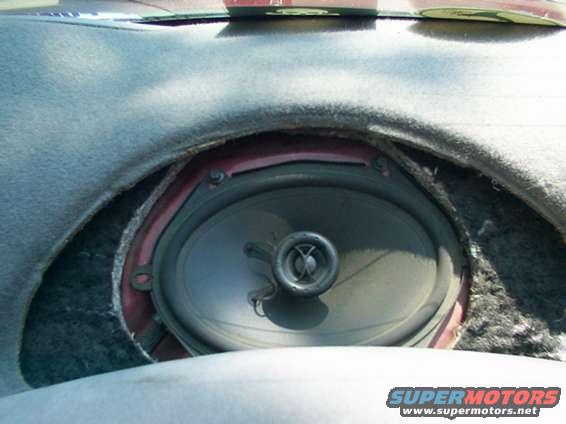 Car dashboard with exposed speaker and frayed trim