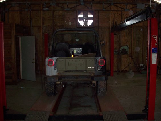 Rear view of a Jeep CJ-5 with a "4 wheel drive" badge