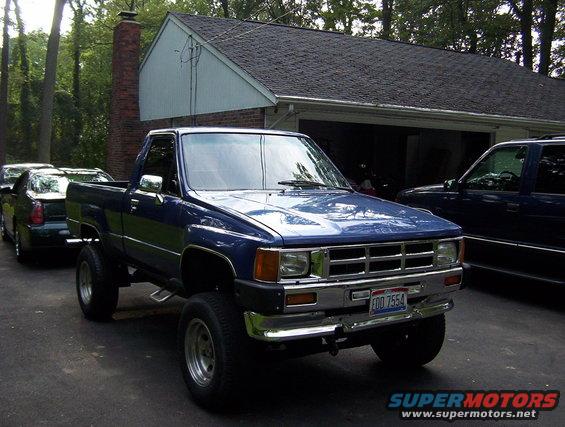 blue pickup truck parked in driveway, another car and SUV behind it