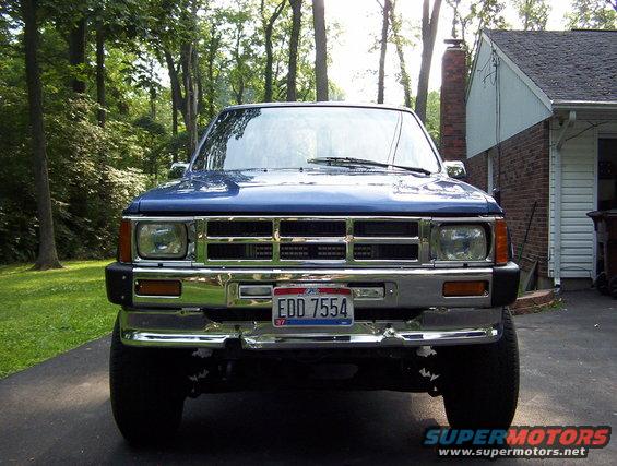 Front view of a blue pickup truck with a chrome grille and bumper. License plate reads EDD 7554