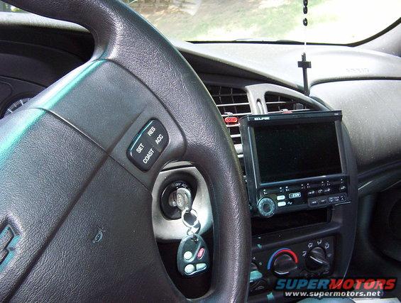 Car interior with steering wheel, dashboard, and aftermarket Eclipse stereo. Keys in ignition