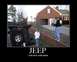 1991 Ford Bronco - A black Jeep Wrangler lies overturned on its side next to a residential street.