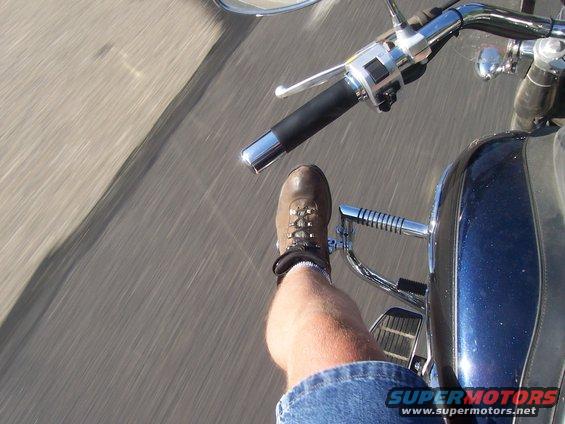 Motorcycle rider's leg and boot, blue fairing