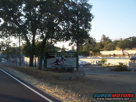 White van parked in front of a building with a sign for Calaveras County Fair
