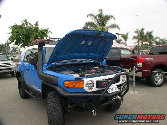 Blue 2007 Toyota FJ Cruiser with hood open, snorkel, and aftermarket bumper