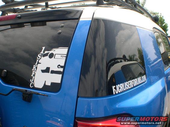 Blue Toyota FJ Cruiser rear quarter panel with a white FJ Cruiser sticker and a "FJCruiserForums.com" sticker