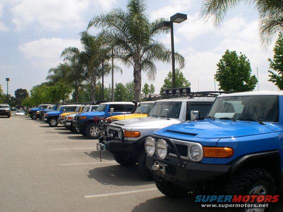 Blue Toyota FJ Cruiser in foreground, parked in a lot with other FJ Cruisers