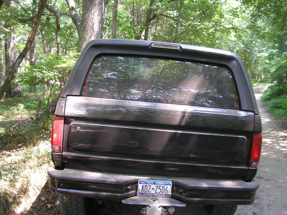 Rear of a dark 1995 Ford Bronco with a cap, New York license plate ADZ-2506