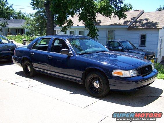 Blue 2002 Ford Crown Victoria parked on driveway, front passenger side visible