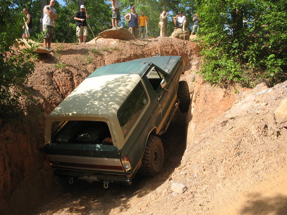 1978 Ford Bronco navigating a steep dirt ditch with people watching from above
