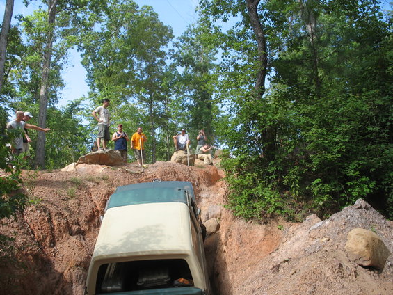 Two-tone 1978 Ford Bronco navigating a steep ditch off-road