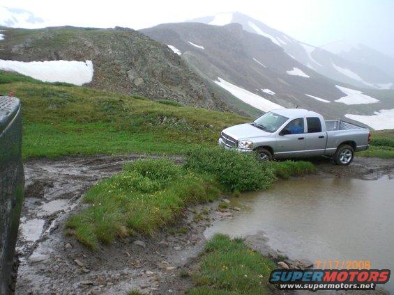 Silver pickup truck parked on muddy mountain road near puddle. Date stamp 7/17/2008