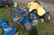 1989 Ford Bronco II - A yellow ATV is in pieces on the grass, with its blue frame and various parts laid out around it.