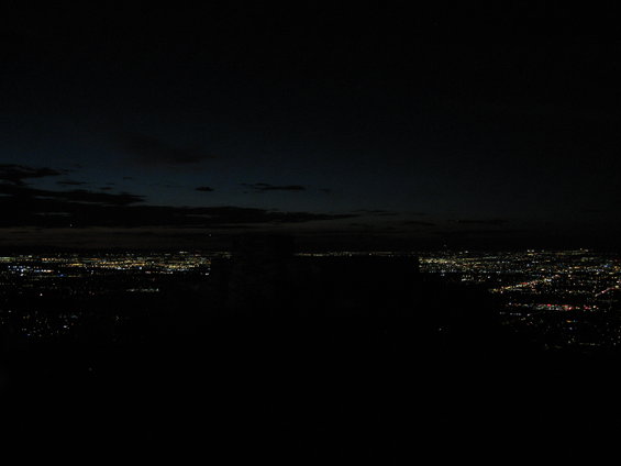 City lights spread across a dark landscape under a twilight sky