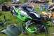 1989 Ford Bronco II - An Arctic Cat snowmobile sits on grass with various parts and other vehicles in the background.