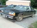 1995 Mercury Grand Marquis - A black sedan with a "5.0" badge on the fender is parked next to a pickup truck.