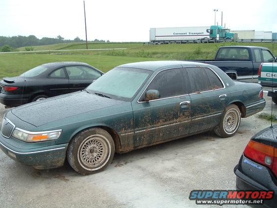 Green 1995 Mercury Grand Marquis, 3q front view, covered in mud