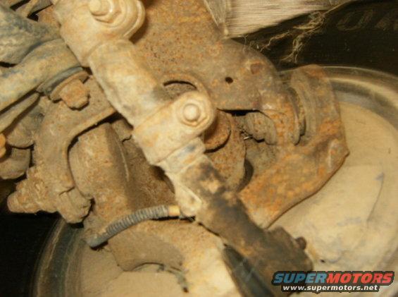 rusted suspension components and part of a tire