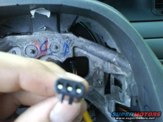 Steering column wiring harness connector with blue and red markings on the column