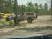 1989 Ford Bronco - A mud-splattered 1989 Ford Bronco is seen parked next to a yellow vehicle in an outdoor setting.