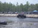 1989 Ford Bronco - A custom-built monster truck navigates a muddy track while spectators watch from the sidelines.