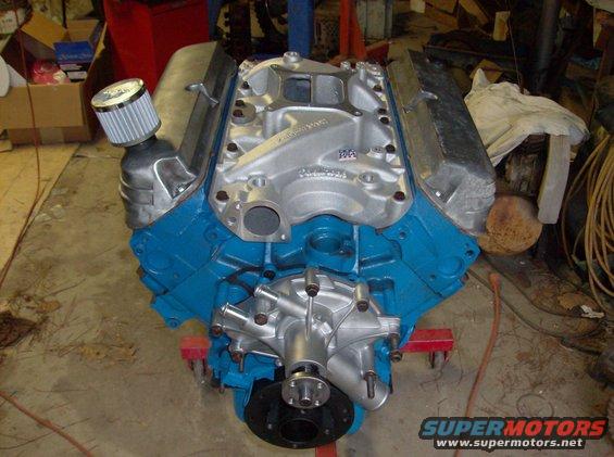 Ford V8 engine with blue block and silver intake manifold, on an engine stand