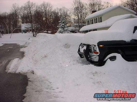 Black truck buried in snow, front view