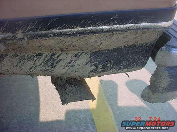 Mud-splattered vehicle exhaust pipe and lower bumper section