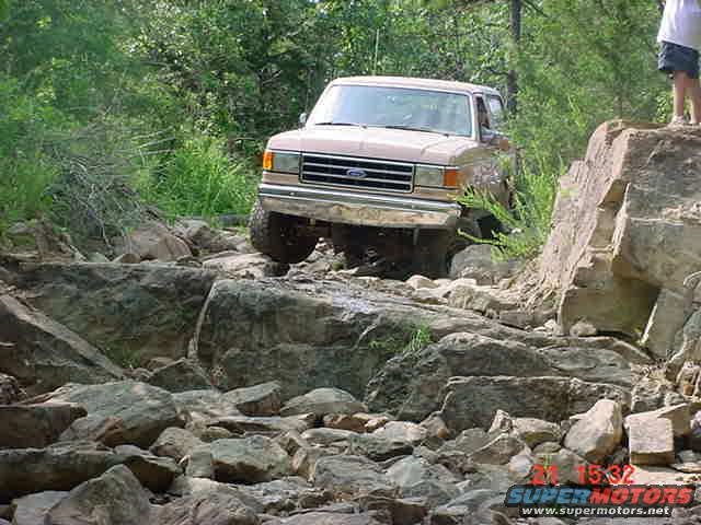 Tan 1989 Ford Bronco navigating rocky terrain