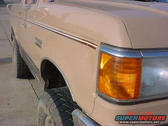Tan 1989 Ford Bronco front fender with chrome trim and amber turn signal