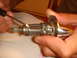1992 Ford Bronco - Close-up of an ignition lock cylinder with a tool being used to manipulate its internal components.