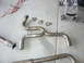 1996 Ford Probe - Exhaust system part with flex joint and gaskets laid out on a concrete surface.