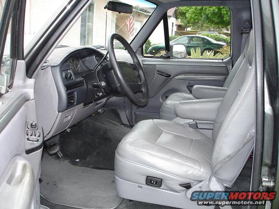 Gray interior of a 1994 Ford Bronco, showing dashboard, steering wheel, and leather seats