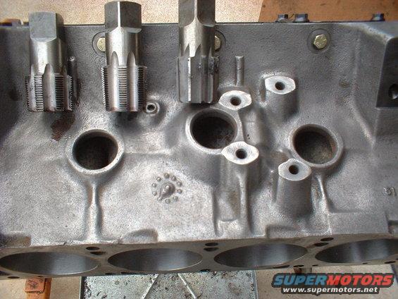 Engine block with three taps inserted into bolt holes