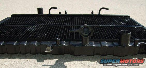 Black car radiator with visible fins and hose connections