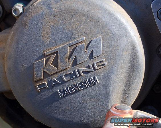 Close-up of a KTM Racing Magnesium engine cover with dirt