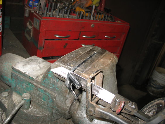 Part clamped in vise, being cut by a reciprocating saw blade