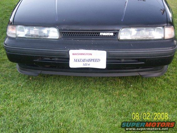 Front of a black 1989 Mazda MX-6 with a license plate that says MAZADASPEED MX-6