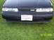 1989 Mazda MX-6 - The front of a black 1989 Mazda MX-6 is shown parked on grass, with a custom license plate.