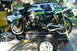 1981 Kawasaki Bayou - A green and purple Kawasaki motorcycle is secured to a trailer, with a white SUV and yellow truck visible.