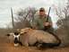 1991 Ford Bronco - Hunter poses with a rifle next to a deceased oryx antelope in a dry, brushy environment.