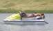 1994 Ford Probe - A person relaxes on a jet ski in the water with a grassy bank in the background.
