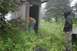 1990 Chevrolet Suburban - Two people are in a remote, overgrown area near a dilapidated wooden outhouse.