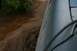 1990 Chevrolet Suburban - Muddy water flows past the side of a vehicle's fender.