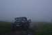 1990 Chevrolet Suburban - Jeep Wrangler on a foggy trail with people gathered around.