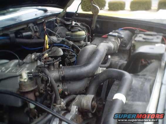 Engine bay of a 1992 Ford Bronco with hoses, wires, and engine components visible