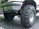 1988 Ford Bronco - Front tire and suspension details of a lifted truck are visible in this close-up shot.