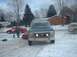 1986 Ford Bronco - A dark blue Ford Bronco is parked in a snowy driveway with two people standing near a red car.