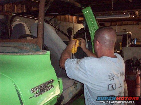 Green 1978 Ford Bronco Ranger interior with man working on dashboard