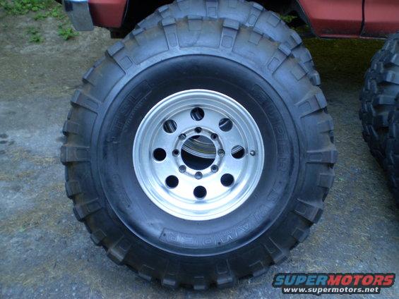 Red vehicle with large off-road tires and silver rims